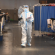 A health worker wearing a personal protective equipment kit walks inside a banquet hall temporarily converted into a covid-19 coronavirus ward in India’s capital city.